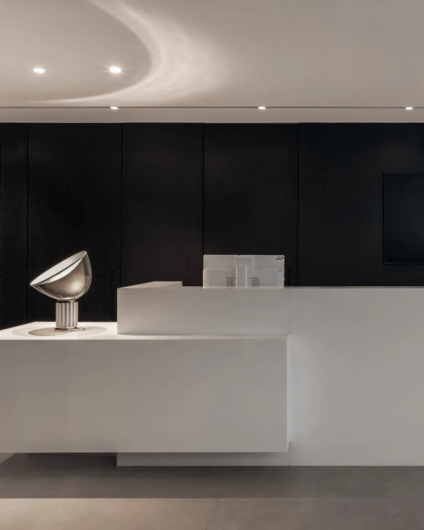 Recepção da Serra Prestige: balcão branco diante de painel de madeira escura